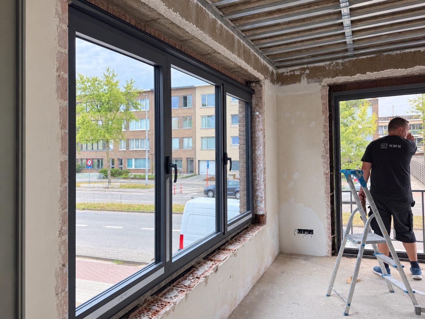 Montage van een grote aluminium raampartij in een woning in Wijnegem